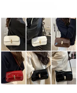Glossy leather underarm bag in white, brown, red, and black shown on a model