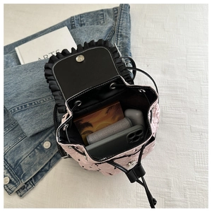 Vue de dessus du sac à dos matelassé rose ouvert montrant l'intérieur et les objets