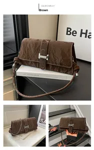 Close-up of vintage brown leather bag with metallic buckle and wrinkled texture