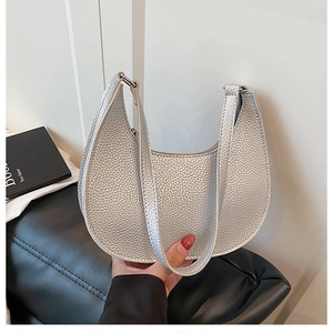 Close-up of silver crescent handbag featuring premium pebble grain texture and metallic finish