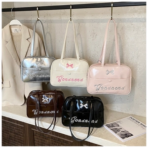 Detail view of stylish bow handbags in five colors with embroidery and glossy finish