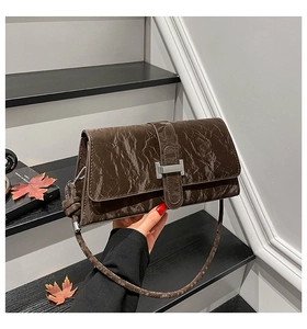 Detail of dark brown pleated leather handbag with metallic H buckle in retro style