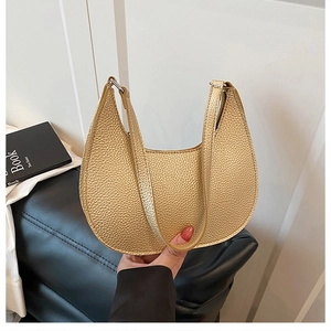 Detail of metallic gold crescent bag with lychee texture and sturdy hardware