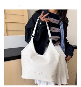 Detailed close-up of the intricate white woven faux leather texture on this tote bag