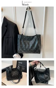 Close-up of black embossed leather tote bag featuring LNBOE prints and chain straps