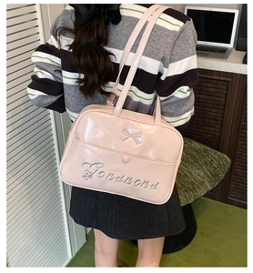 Detailed view of pink glossy tote bag featuring bow accent and Gonanond embroidery