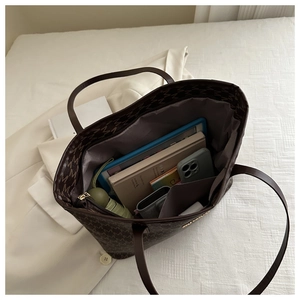 Macro shot of spacious brown monogram tote bag interior showing storage for daily essentials