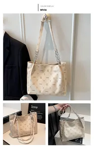 Detail of white tote bag featuring lychee texture and chain-link shoulder strap