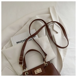 Top-down view of a brown lychee-patterned leather handbag with a gold turn-lock closure