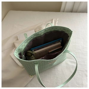Mint green tote bag showing spacious interior with books, tablet, and foldable umbrella