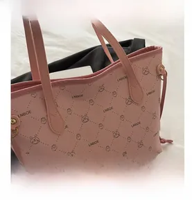 Détail d'un sac cabas rose avec des imprimés de lapins mignons et texture en cuir