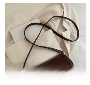 Detail showing high-quality dark coffee leather texture and golden metal buckle of the square bag