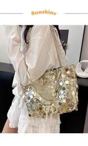 Close-up of golden sequins on tote bag with a pearl beaded bow pendant accessory