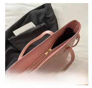 Vue détaillée du sac cabas rose avec fermeture éclair dorée et texture cuir monogramme