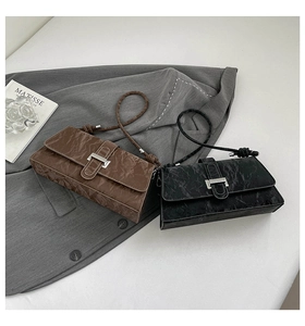 Detail of pleated texture and silver buckle on black and brown crossbody bags