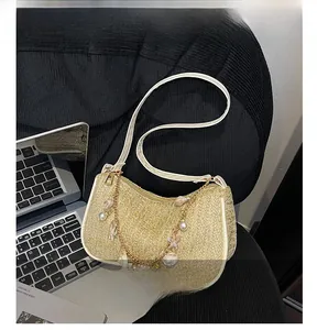 Détails du sac en paille beige avec breloques de perles et finitions en cuir blanc