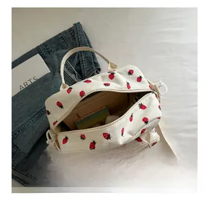 Internal capacity of white corduroy shoulder bag with strawberry print and zipper