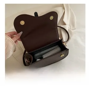 Detail view of deep brown saddle bag interior showing capacity for phone and umbrella