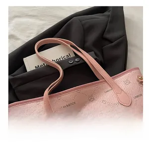Détail du sac cabas en cuir rose avec motifs de lapins sur un blazer noir chic