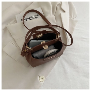 Deep brown litchi grain leather bag with gold buckle showing spacious inner compartment