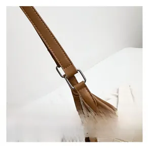 Detail of premium silver square buckle and brown leather strap on woven tote bag