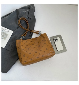 Close-up of brown leather tote bag with LNBOE monogram and rabbit pattern