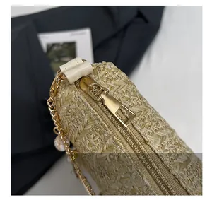 Détail macro de la fermeture éclair dorée et bordure en cuir sur sac en paille