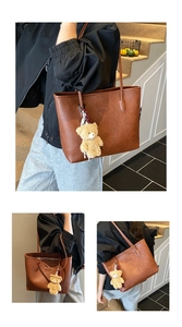 Detail of vintage brown textured tote bag with Fashion embossing and bear charm