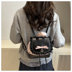 Detail of sweet floral lace backpack with pink bow and heart pendant on model