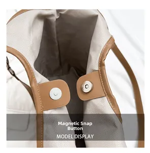 Detail of magnetic snap closure and woven lining in a large brown leather tote bag