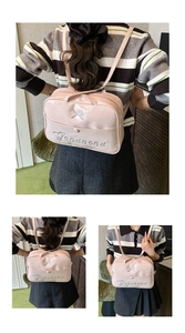 Detail of pink patent leather backpack featuring silver bow embroidery and shoulder straps