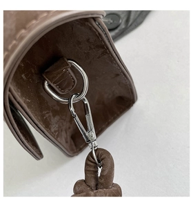 Detail of brown vintage crossbody bag showing silver metal D-ring and lobster clasp hardware