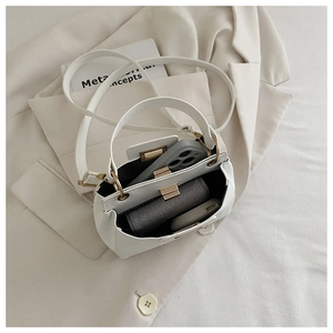 Detail view of the spacious ivory lychee pattern leather bag interior with gold hardware