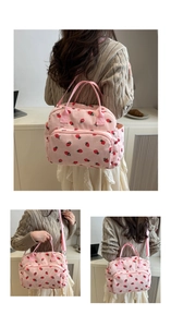 Détail du sac à lunch en velours rose avec motifs de fraises et poches latérales pratiques