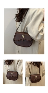 Detail of dark brown leather saddle bag with gold H clasp and wavy flap design