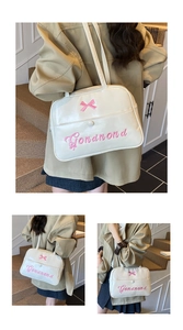 Close-up of beige tote bag with pink bow embroidery and magnetic snap closure