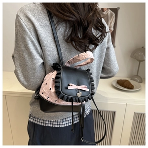 Detail view of balletcore backpack with pink ribbon bow and heart pendant on a model