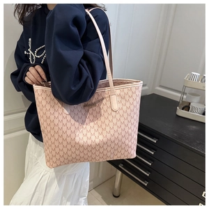 Close-up of pink tote bag with letter M monogram pattern and slim leather shoulder straps