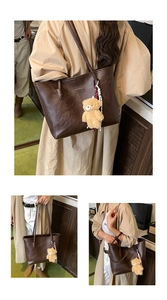 Detail of vintage brown tote bag with fashion tag and cute plush bear accessory