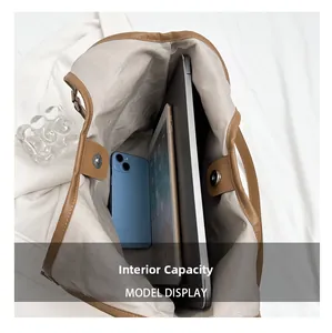 Large capacity interior of brown leather tote showing storage for laptop and phone