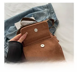 Detail shot of brown corduroy crossbody bag featuring a secure metal magnetic clasp