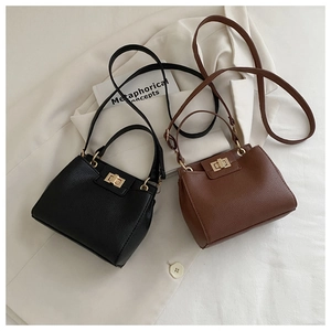 Detailed shot of black and brown lychee grain leather mini bucket bags with gold hardware