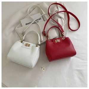 Detail of red and white lychee texture leather bags with gold turn-lock and handles