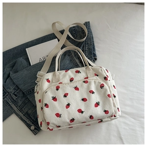 Détail du sac en velours côtelé blanc avec imprimés fraises et poches latérales