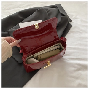 Interior view of burgundy patent leather shoulder bag with phone and wallet inside
