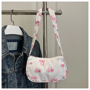 Detail of pink rose and bow prints on a white canvas shoulder bag for women