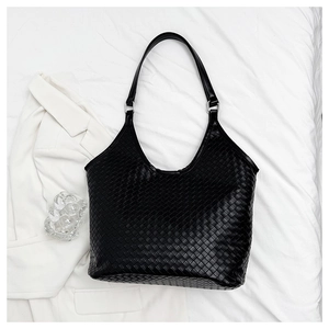 Detailed close-up of woven leather texture on a large black minimalist tote bag