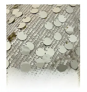 Detailed view of shimmering silver sequins densely stitched on white mesh fabric surface
