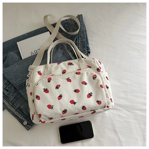 Détail du sac à lunch en velours côtelé fraise avec poche zippée et bandoulière