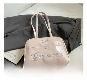 Detail of pink PU leather backpack with silver bow embroidery and front flap pocket